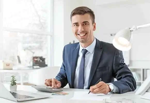 man seated at desk writing consultancy document
