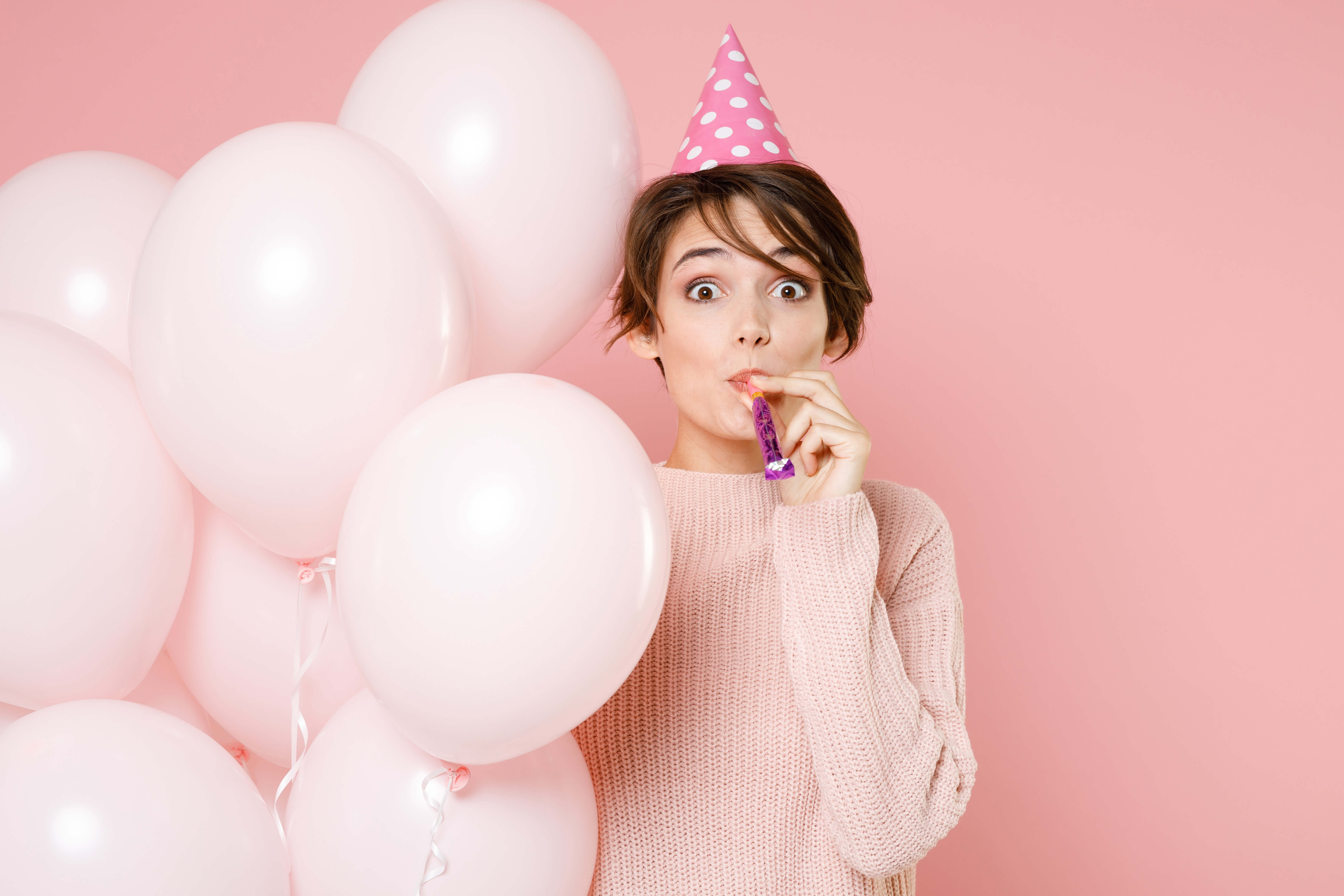 Girl with balloons and party hat